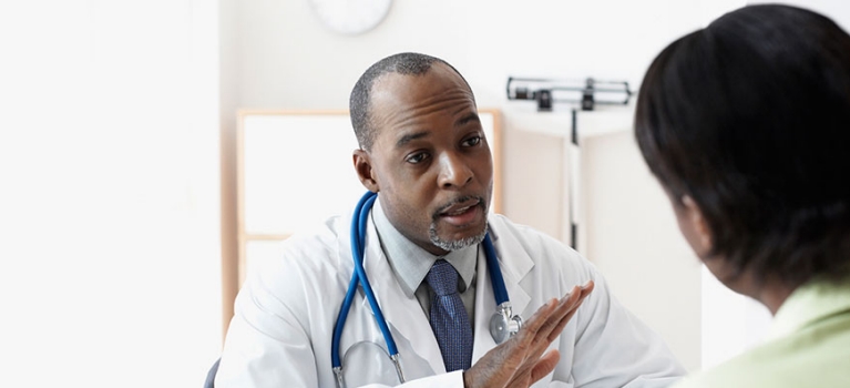 Seated doctor talking to seated patient